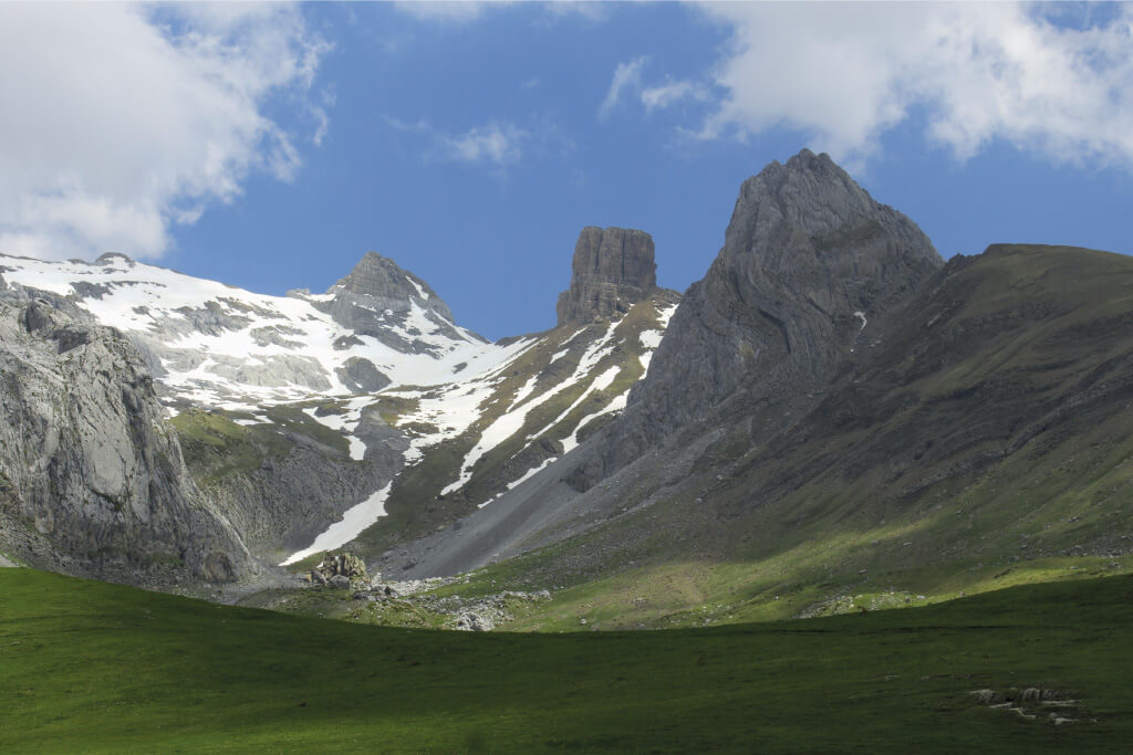 imagen de montañas sobre un valle de praderas verdes